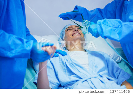 Surgery, anesthesia and woman with oxygen mask for medical service, operation and procedure. Healthcare, hospital and surgeons with gas, breathing and ventilation equipment for patient in theater Surgery, anesthesia and woman with oxygen mask for medical service, operation and procedure. Healthcare, hospital and surgeons with gas, breathing and ventilation equipment for patient in theater 137411466