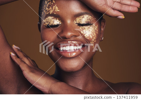 Gold, creative and art on black woman face with makeup for beauty aesthetics isolated in a studio brown background. Smile, luxury and happy person with cosmetic glamour or design for skincare Gold, creative and art on black woman face with makeup for beauty aesthetics isolated in a studio brown background. Smile, luxury and happy person with cosmetic glamour or design for skincare 137411959