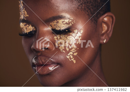Gold, creative and black woman with makeup for beauty aesthetics isolated in a studio brown background eyes closed. Art, luxury and face of African person with cosmetic glamour or design for skincare 137411982