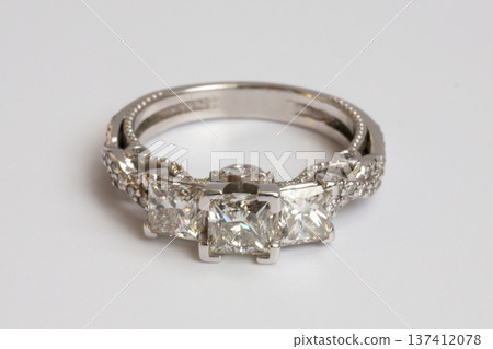 Engagement diamond wedding ring group on white. A white gold ring with large natural princess-cut or Square Modified Brilliant diamonds. Engagement diamond wedding ring group on white. A white gold ring with large natural princess-cut or Square Modified Brilliant diamonds. 137412078