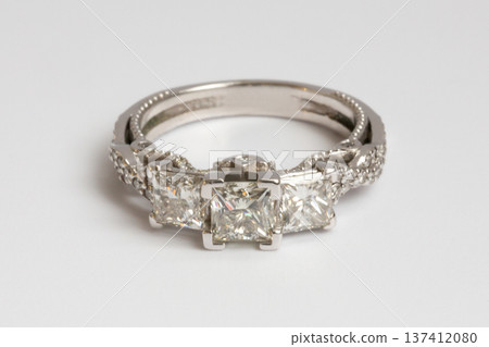 Engagement diamond wedding ring group on white. A white gold ring with large natural princess-cut or Square Modified Brilliant diamonds. Engagement diamond wedding ring group on white. A white gold ring with large natural princess-cut or Square Modified Brilliant diamonds. 137412080