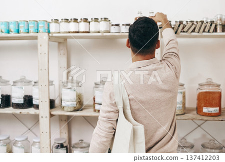 Man, back and shopping by shelf in grocery store for healthy food, nutrition and wellness product sales. Choice, decision and customer nutritionist in supermarket for retail purchase, buying or deal Man, back and shopping by shelf in grocery store for healthy food, nutrition and wellness product sales. Choice, decision and customer nutritionist in supermarket for retail purchase, buying or deal 137412203