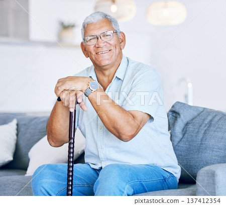 Portrait, home and old man with a walking stick, relax and support with retirement, peace or calm on a couch. Senior person in a living room, elder or pensioner on a sofa, cane or health with a smile 137412354