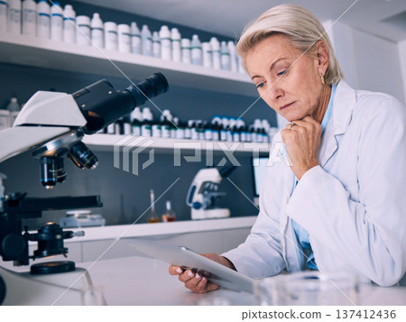 Science, tablet and thinking with woman in laboratory for research, medical and pharmacy. Medicine, healthcare and digital report with mature scientist reading online for email, data and results 137412436