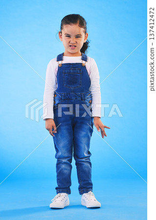 Angry, attitude and portrait of child on blue background with upset, mad and frustrated facial expression. Behaviour, youth and young girl with body language for anger, tantrum and emotion in studio Angry, attitude and portrait of child on blue background with upset, mad and frustrated facial expression. Behaviour, youth and young girl with body language for anger, tantrum and emotion in studio 137412472