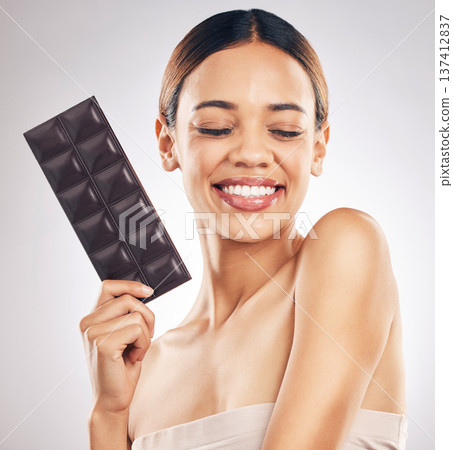 Woman, chocolate and thinking of diet for skincare, beauty and health or wellness on a white background. Young person or model with cocao product, food or candy for skin care or dermatology in studio Woman, chocolate and thinking of diet for skincare, beauty and health or wellness on a white background. Young person or model with cocao product, food or candy for skin care or dermatology in studio 137412837