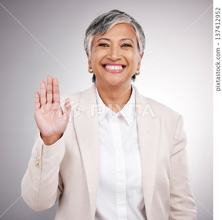 Portrait, business and a studio wave from a woman for hello, welcome or a professional pledge. Happy, mature and a corporate manager or person with a hand for greeting or thank you on a backdrop Portrait, business and a studio wave from a woman for hello, welcome or a professional pledge. Happy, mature and a corporate manager or person with a hand for greeting or thank you on a backdrop 137412952