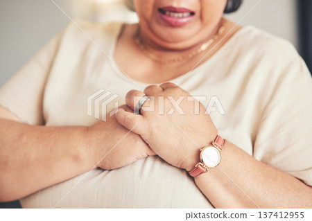 Heart attack, healthcare and closeup of a senior woman with chest pain, injury or accident. Medical emergency, breathe and zoom of elderly female hands with lung sickness or infection at her home. Heart attack, healthcare and closeup of a senior woman with chest pain, injury or accident. Medical emergency, breathe and zoom of elderly female hands with lung sickness or infection at her home. 137412955