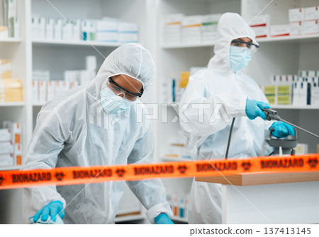Biohazard, chemical and cleaning with people in a pharmacy for decontamination after a medical accident. Hazmat, spray or disinfect with healthcare personnel in a drugstore to sanitize and isolate Biohazard, chemical and cleaning with people in a pharmacy for decontamination after a medical accident. Hazmat, spray or disinfect with healthcare personnel in a drugstore to sanitize and isolate 137413145