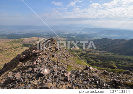 A landscape of majestic scale, with mountains and valleys stretching out beyond the rocky ridge A landscape of majestic scale, with mountains and valleys stretching out beyond the rocky ridge 137413334