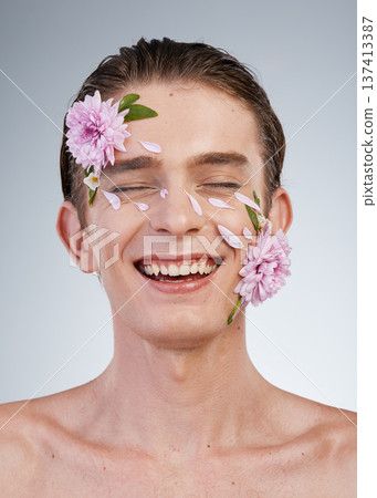 Happy, skincare and flowers on face of man in studio for spring, natural cosmetics and creative. Glow, self love and floral beauty with model on white background for makeup, spa treatment or wellness Happy, skincare and flowers on face of man in studio for spring, natural cosmetics and creative. Glow, self love and floral beauty with model on white background for makeup, spa treatment or wellness 137413387