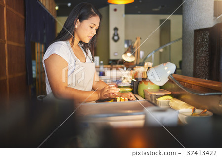 Chinese food, cooking and an asian woman in a sushi restaurant to serve a traditional meal for nutrition. Kitchen, recipe and preparation with a young chef in an eatery for fine dining cuisine Chinese food, cooking and an asian woman in a sushi restaurant to serve a traditional meal for nutrition. Kitchen, recipe and preparation with a young chef in an eatery for fine dining cuisine 137413422