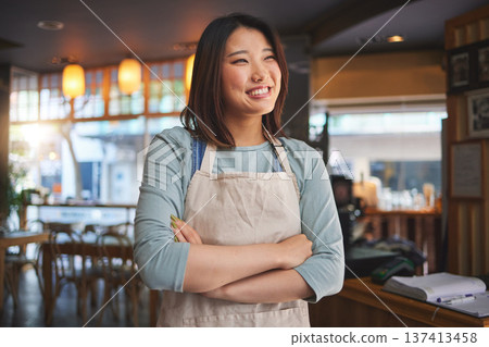 Smile, thinking and arms crossed with an asian woman in a restaurant working as a waitress for service. Hospitality, happy and idea with a young employee in a chinese eatery for local cuisine 137413458