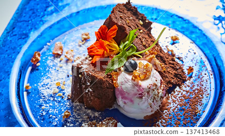 Gourmet chocolate cake served with berry-swirl ice cream and edible flowers Gourmet chocolate cake served with berry-swirl ice cream and edible flowers 137413468