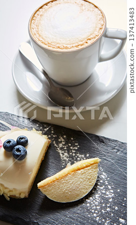 Elegant white chocolate mousse dome dessert topped with fresh blueberries and a floral petal Elegant white chocolate mousse dome dessert topped with fresh blueberries and a floral petal 137413483