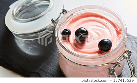 Luxury pink berry mousse served in an artisanal glass jar with fresh blueberries 137413529