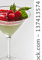 Gourmet panna cotta served in a martini glass with a vibrant raspberry coulis swirl and fresh mint 137413574