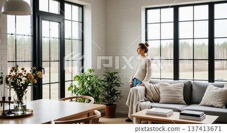 一幅展現新生活的畫面：一位女性在擺滿綠植的明亮客廳閱讀。 137413671