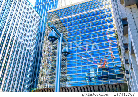 東京火炬,日本東京的城市景觀。東京車站(日本橋出口)附近的監視器和透過窗戶映照出的大手町重建計畫… 東京火炬,日本東京的城市景觀。東京車站(日本橋出口)附近的監視器和透過窗戶映照出的大手町重建計畫… 137413768