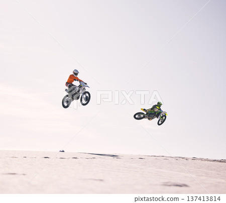Dune, jump and men on motorbike together for practice, training and extreme sports energy in nature. Professional dirt biking challenge, friends and danger with motorcycle competition on desert hill. 137413814
