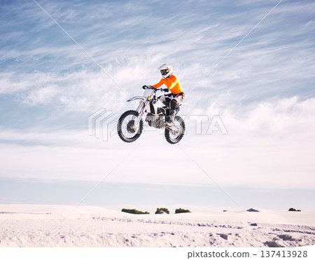 Bike, speed and jump with a man on sand riding a vehicle in the desert for adventure or adrenaline. Motorcycle, training and freedom with an athlete in the sky in nature for power or competition Bike, speed and jump with a man on sand riding a vehicle in the desert for adventure or adrenaline. Motorcycle, training and freedom with an athlete in the sky in nature for power or competition 137413928