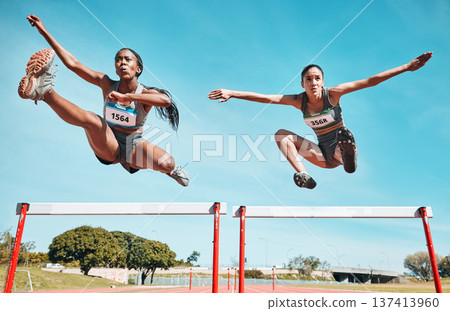 Sports, hurdles and team of women on track running in a race, marathon or competition in stadium. Fitness, workout and female athletes jumping with speed and energy for outdoor training or practice. Sports, hurdles and team of women on track running in a race, marathon or competition in stadium. Fitness, workout and female athletes jumping with speed and energy for outdoor training or practice. 137413960