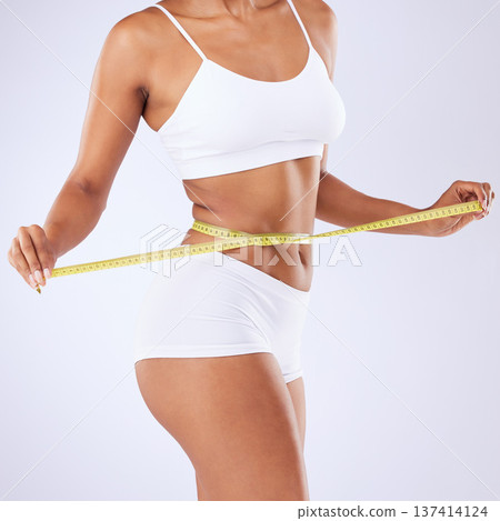 Body, woman and measurement to lose weight on a white background for fitness, health or wellness. Gym, training and a girl or model with a tape to check exercise progress or results on a backdrop Body, woman and measurement to lose weight on a white background for fitness, health or wellness. Gym, training and a girl or model with a tape to check exercise progress or results on a backdrop 137414124