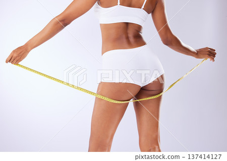 Fitness, butt and health with woman and tape in studio for weight loss, detox and workout. Wellness, diet and progress with closeup of person on white background for results, cosmetics or measurement Fitness, butt and health with woman and tape in studio for weight loss, detox and workout. Wellness, diet and progress with closeup of person on white background for results, cosmetics or measurement 137414127