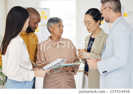 Tablet, collaboration and documents with a business team talking in the office during a meeting. Technology, paper and serious with a manager coaching a designer group in a professional workplace 137414456