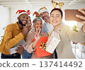 Business people, Christmas selfie and staff for smile, present or peace sign for celebration, diversity or party. Men, women and photography for funny xmas memory, friends or gift for social media 137414492
