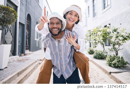 Happy interracial couple, travel or piggyback in city on romantic date to play a fun outdoor game. Smile, pointing or excited black man carrying gen z woman or walking for urban sightseeing together Happy interracial couple, travel or piggyback in city on romantic date to play a fun outdoor game. Smile, pointing or excited black man carrying gen z woman or walking for urban sightseeing together 137414517
