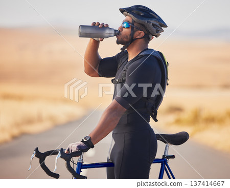 Fitness, nature and man cyclist drinking water at race, marathon or competition training. Sports, workout and thirsty male athlete with hydration for health at an outdoor cardio exercise with bicycle Fitness, nature and man cyclist drinking water at race, marathon or competition training. Sports, workout and thirsty male athlete with hydration for health at an outdoor cardio exercise with bicycle 137414667