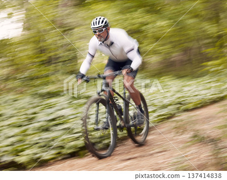 Fast, cycling and man on a bike in nature for fitness, sports or a competition. Energy, mountains and a male cyclist on a bicycle in the woods with speed for exercise, cardio or training in a forest Fast, cycling and man on a bike in nature for fitness, sports or a competition. Energy, mountains and a male cyclist on a bicycle in the woods with speed for exercise, cardio or training in a forest 137414838