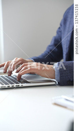 Close up of businessman's hands typing on laptop keyboard, working diligently in a modern office setting, wearing a suit and watch. Business people concept Close up of businessman's hands typing on laptop keyboard, working diligently in a modern office setting, wearing a suit and watch. Business people concept 137415158