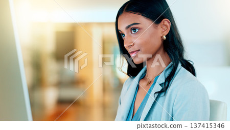 Business woman reading information on a computer screen while working in an office. Closeup on face of one confident young entrepreneur and focused expert carefully analyzing ideas and plans online 137415346
