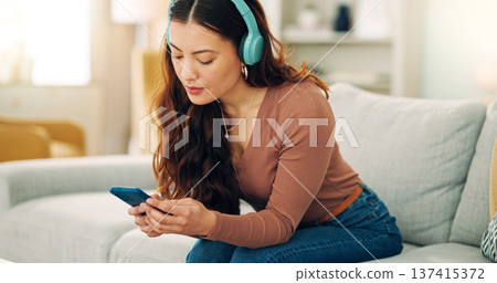 Woman, phone or music headphones on relax sofa in house or Singaporean home living room. Smile,enjoy or happy student with mobile technology for podcast, dance radio or audio playlist app in lockdown 137415372
