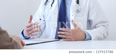 Adult doctor gesturing with hands while explaining diagnosis to patient during medical consultation in hospital office, healthcare and medical concept. Medicine concept Adult doctor gesturing with hands while explaining diagnosis to patient during medical consultation in hospital office, healthcare and medical concept. Medicine concept 137415786