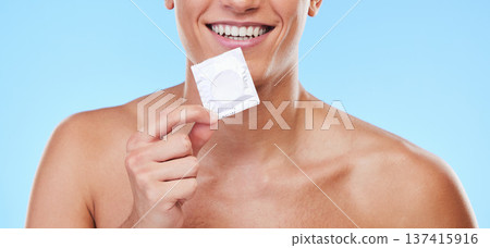 Smile, hand and man with a condom on a blue background for security or birth control in sex. Happy, health and person or guy showing protection or a product for sexual safety choice or contraception Smile, hand and man with a condom on a blue background for security or birth control in sex. Happy, health and person or guy showing protection or a product for sexual safety choice or contraception 137415916