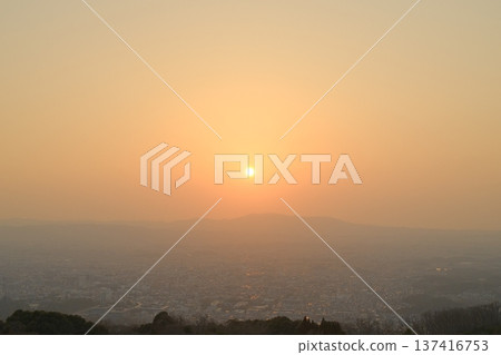 A view of the city and the soft orange sunset from Wakakusa Mountain. A twilight landscape with ample empty space in the sky. 137416753