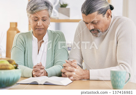 Praying, book and senior couple at home with bible study and religion together in marriage. Prayer, faith and elderly people with worship, learning and christian solidarity with love and care 137416981