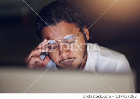 Businessman, headache and stress at computer at night in office working late on deadline. Tired entrepreneur person with glasses and hands on head for pain, burnout or depression and fatigue at work Businessman, headache and stress at computer at night in office working late on deadline. Tired entrepreneur person with glasses and hands on head for pain, burnout or depression and fatigue at work 137417268