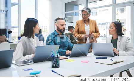 Business people, laptop and meeting, marketing team at digital agency, creative group and research online. Man, women and diversity, productivity and work together, senior leader and brand strategy 137417441