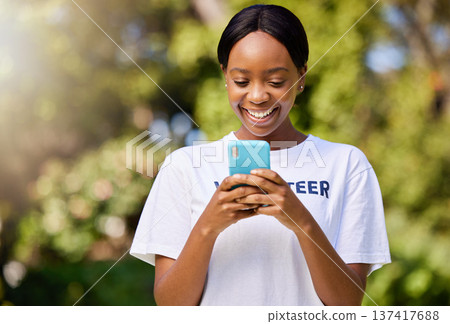 Smile, park volunteering and black woman with a phone for social media, chat or communication. Happy, web and African volunteer or charity worker in nature for cleaning with a mobile for notification 137417688