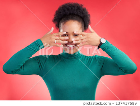 Hands, cover face and woman in studio with hiding and eyes peak with a smile. African female person, red background and happy with secret and model from Chicago with gossip announcement and portrait 137417689