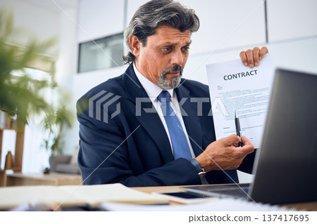 Contract, video call and businessman with a document in the office talking to an online client. Discussion, paperwork and mature professional male lawyer in a virtual meeting on a laptop in workplace Contract, video call and businessman with a document in the office talking to an online client. Discussion, paperwork and mature professional male lawyer in a virtual meeting on a laptop in workplace 137417695