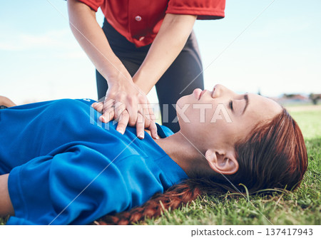 Cpr, outdoor and hands on chest, women and help on a field, resuscitation and medical emergency. Closeup, player outside and heart attack with volunteer, accident and first aid to rescue a person Cpr, outdoor and hands on chest, women and help on a field, resuscitation and medical emergency. Closeup, player outside and heart attack with volunteer, accident and first aid to rescue a person 137417943