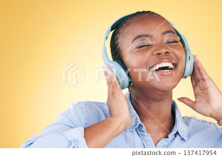 Singer, music and black woman on headphones, smile and listening in studio isolated on a yellow background. Excited, radio and African person streaming podcast, audio and sound, hearing and freedom. Singer, music and black woman on headphones, smile and listening in studio isolated on a yellow background. Excited, radio and African person streaming podcast, audio and sound, hearing and freedom. 137417954