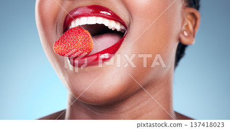 Woman, eating and strawberry, red lipstick and beauty, makeup closeup isolated on blue background. Fruit, healthy and model in a studio with bold cosmetic product, mouth and cosmetology with shine Woman, eating and strawberry, red lipstick and beauty, makeup closeup isolated on blue background. Fruit, healthy and model in a studio with bold cosmetic product, mouth and cosmetology with shine 137418023