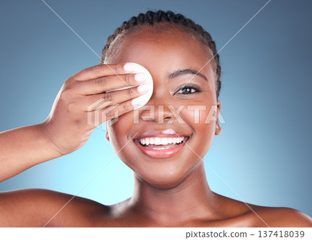 Black woman, portrait smile and cotton pad for makeup removal against a blue studio background. Face of happy African female person with swab in beauty for cleaning, hygiene or facial treatment 137418039