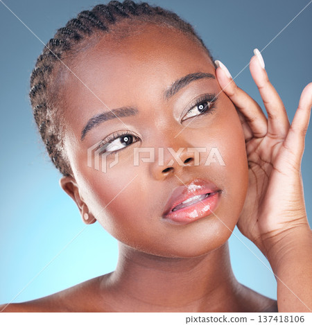Beauty glow, skin and face of a black woman with dermatology and natural makeup. Headshot of African person on blue background in studio with cosmetics and thinking of facial with hand for soft touch Beauty glow, skin and face of a black woman with dermatology and natural makeup. Headshot of African person on blue background in studio with cosmetics and thinking of facial with hand for soft touch 137418106